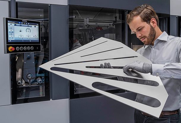 Man with large laser part in front of deburring machine