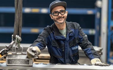 Heimann employee at the leveling machine with sheet metal part